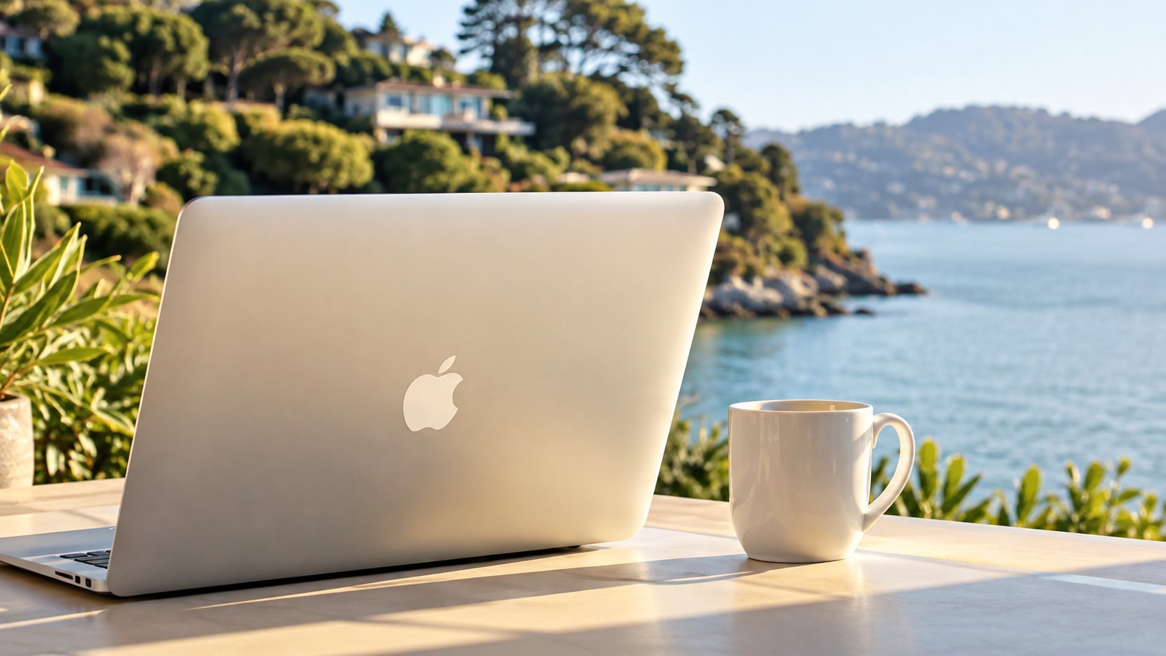 A laptop and a cup of coffee on a table overlooking Richardson Bay in Sausalito